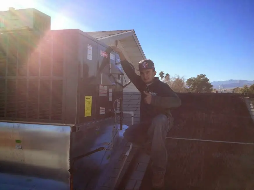 HVAC technician performing Heat Pump Repair on a rooftop unit in Oxford